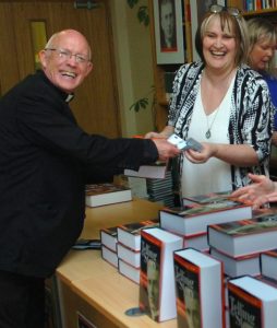 Fr Tommie Towey receives his copy at the book launch in the Newman Institute from Anne Sweeney.